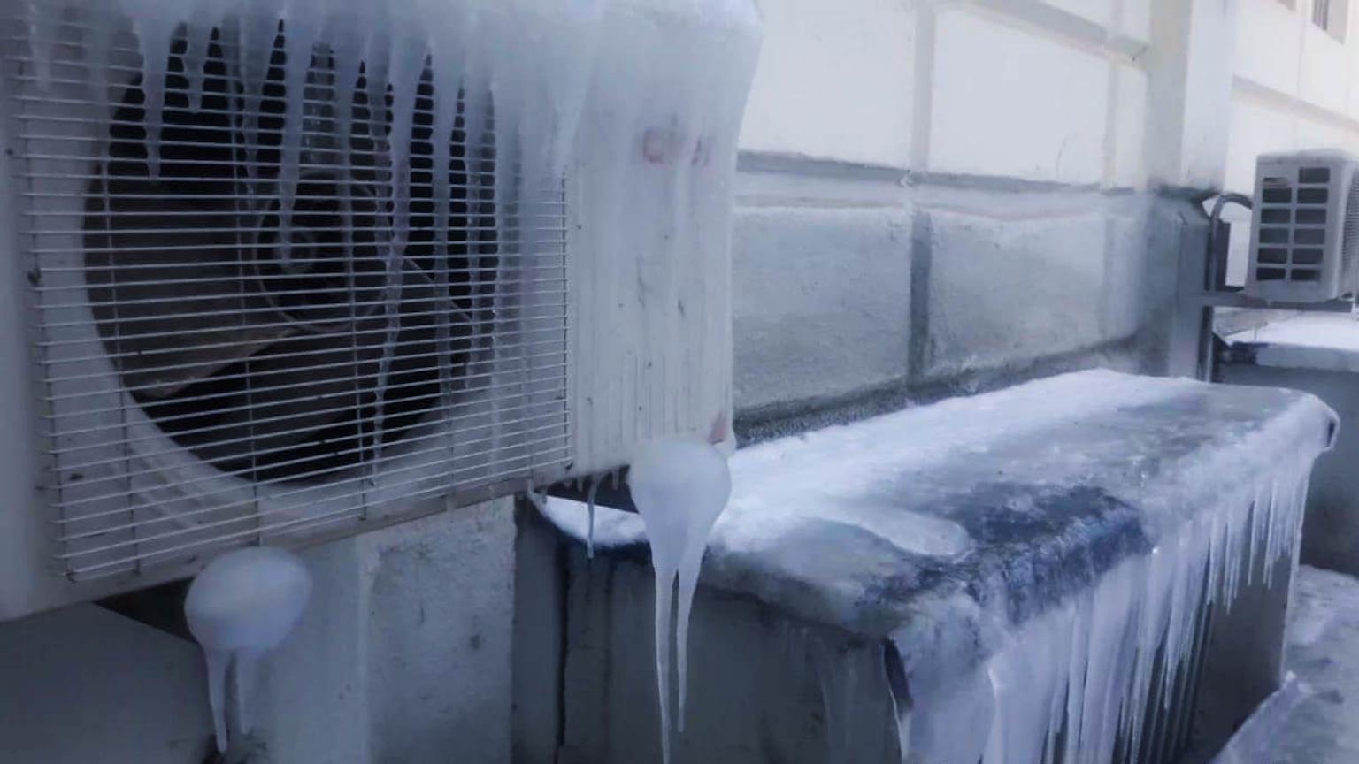 Technician repairing a frozen air conditioner