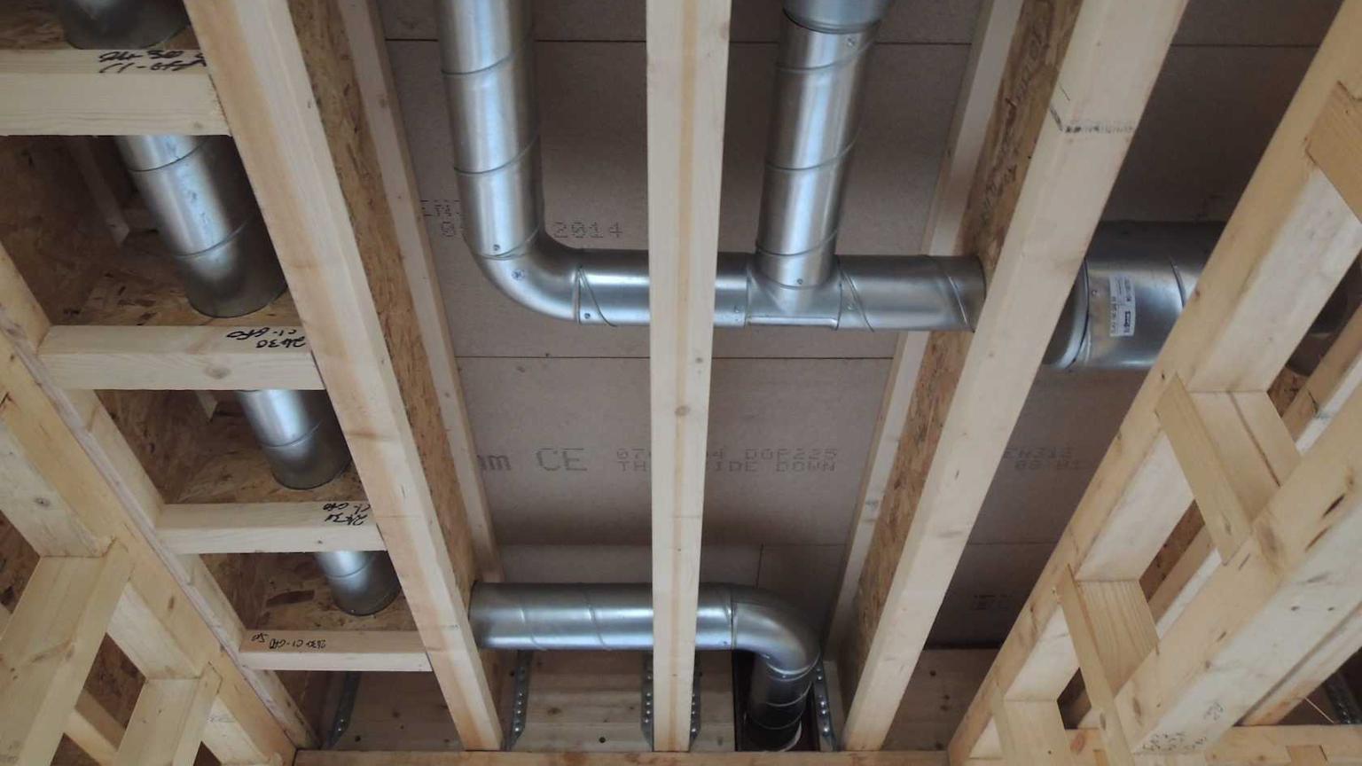 Technician installing ductwork in a residential property