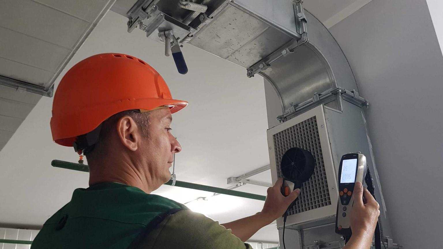 Technician performing ductwork repair in a residential property