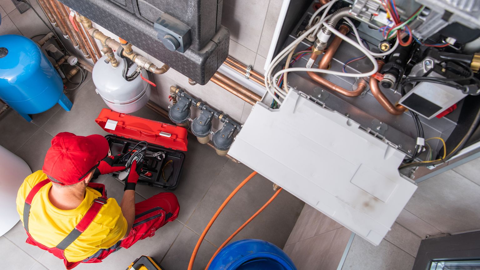 Technician installing an electric furnace in a residential home