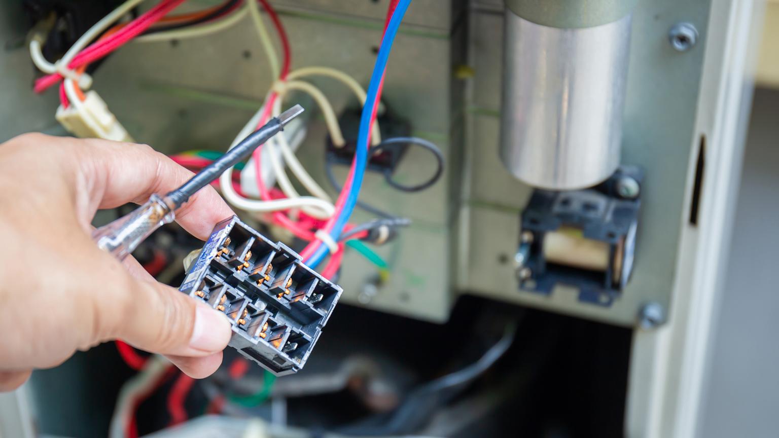 Technician performing maintenance on an electric furnace