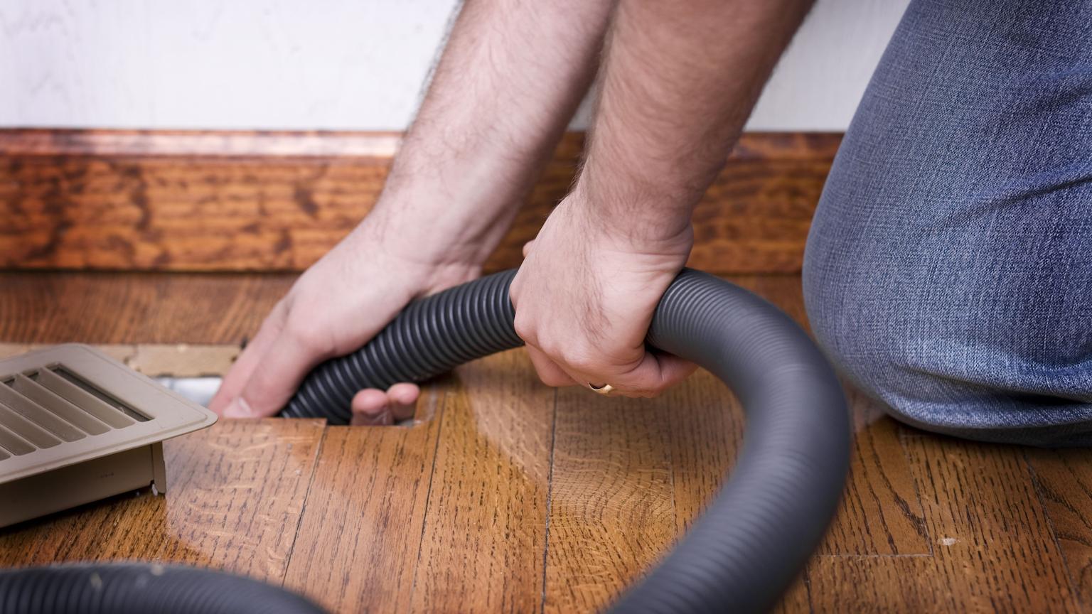 Technician cleaning HVAC vents to improve air quality - HVA Climate Control